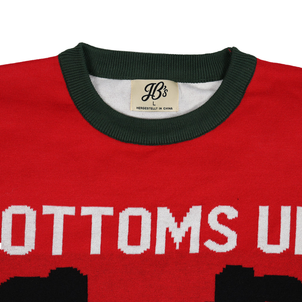 Red ugly sweater with white text and green collar, featuring a brand label.