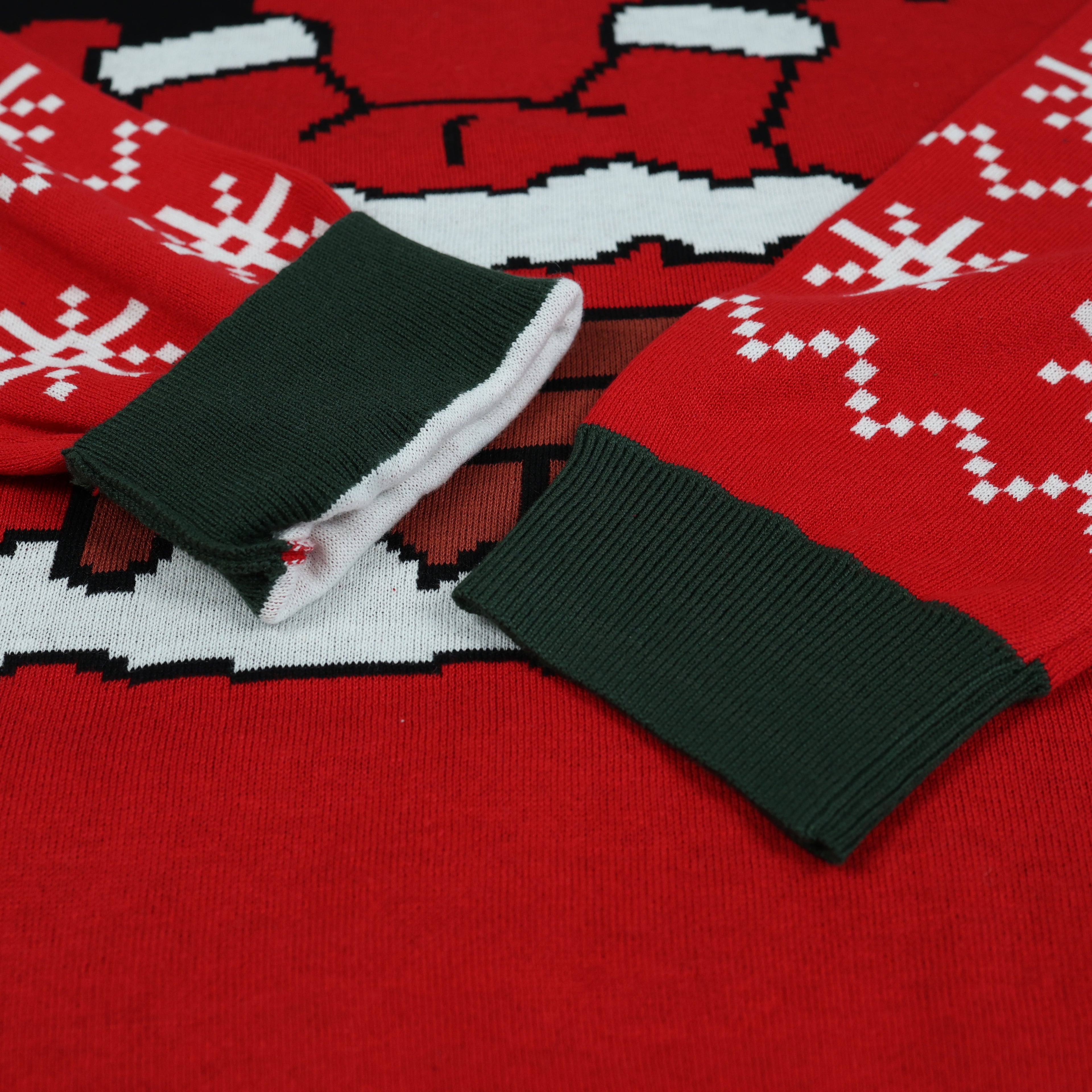 Red ugly christmas sweater with black and white pattern and green cuffs on a red background