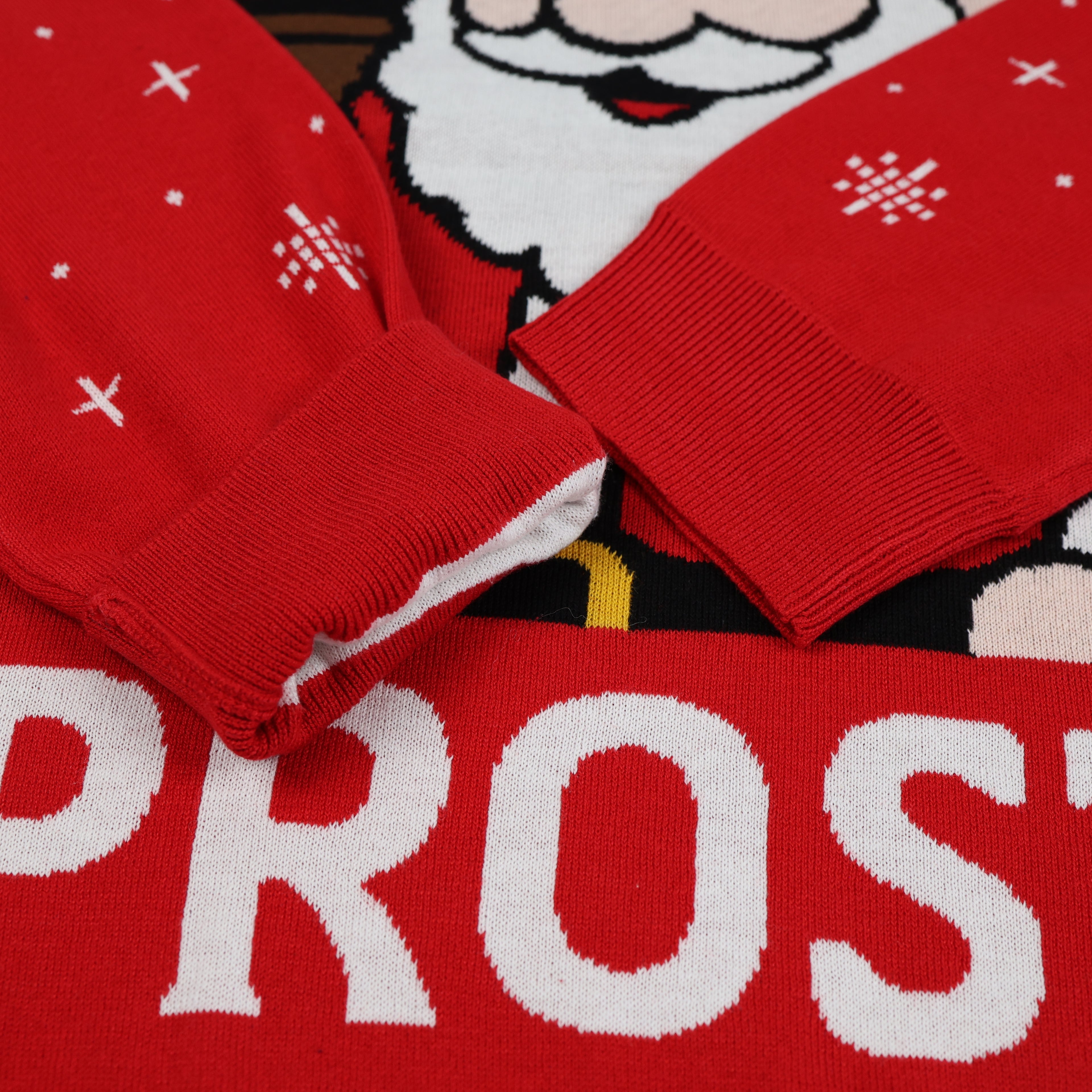 Red Christmas-themed sweater with white text and patterns on a dark background